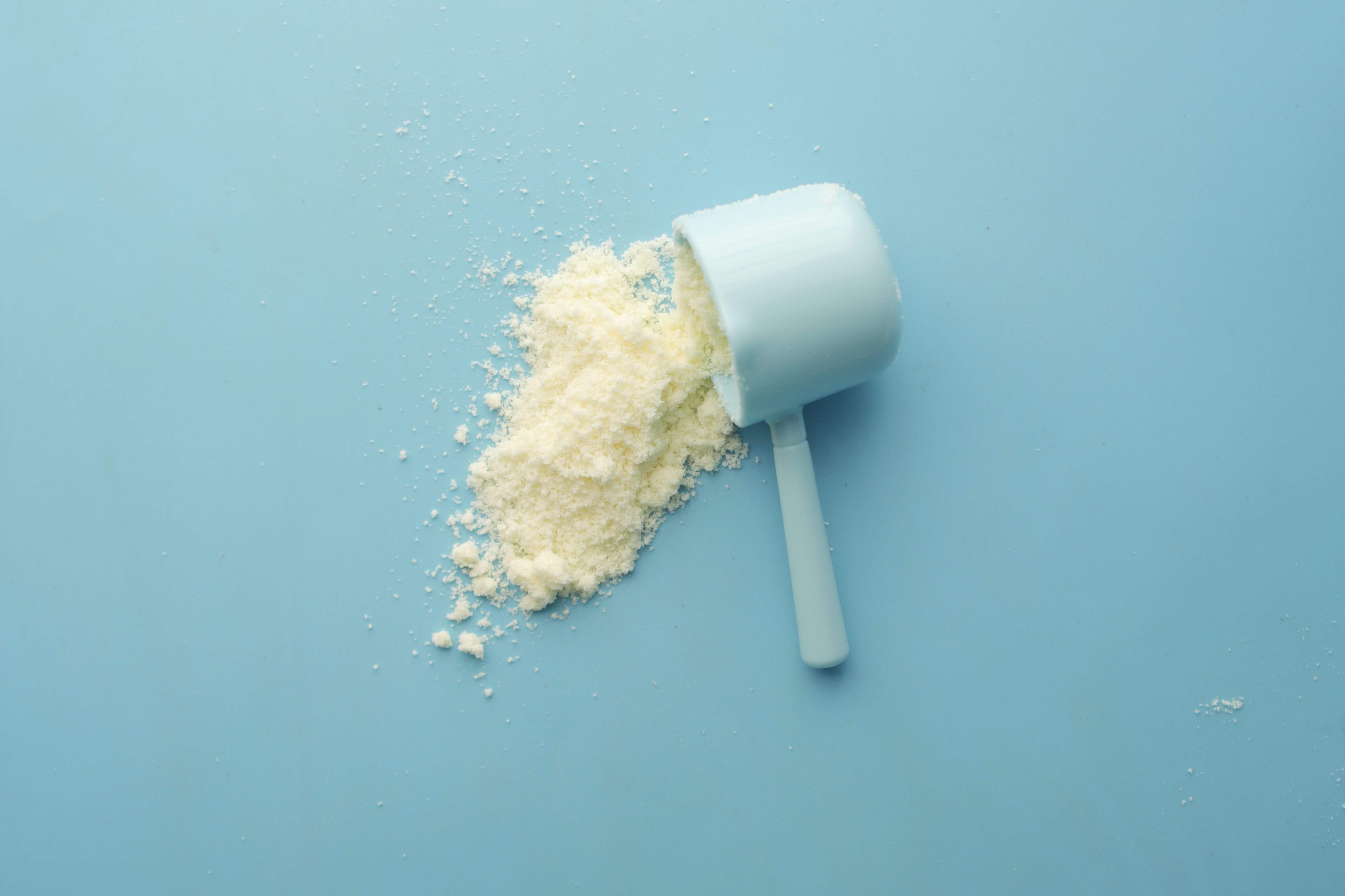 Blue scoop with supplements on a blue background